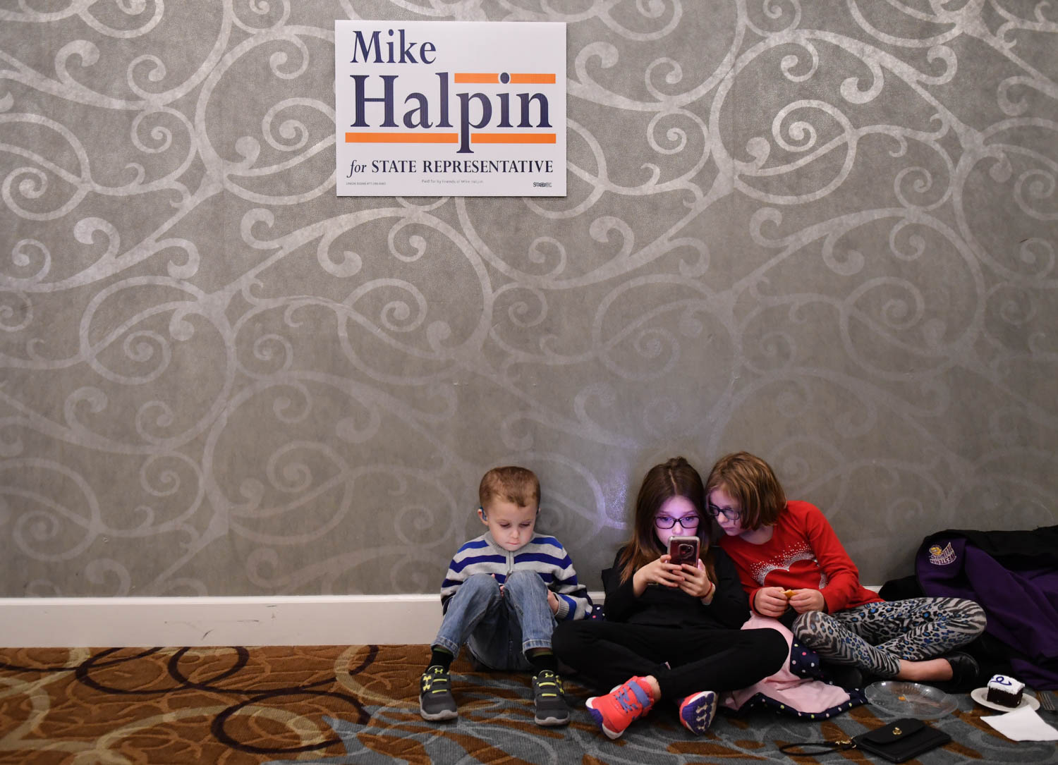 Kaysen Stokes, 4, Kenlie Stokes, 7 and  Kylar Elliott, 7, pass the time by playing games on their devices during the Rock Island County Democrats' election night party, at the Holiday Inn Rock Island, Tuesday Nov. 5, 2018.  (Todd Mizener - Dispatch/Argus) 