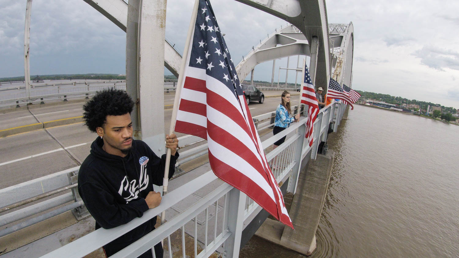 Darron Austin, of Rock Island, and approximately 200 other volunteers line the length of the Master Sgt. Stanley Talbot Memorial Bridge over the Mississippi River between Rock Island and Davenport with U.S. Flags in honor of Flag Day Thursday, June 14, 2018. (Todd Mizener - Dispatch/Argus) 