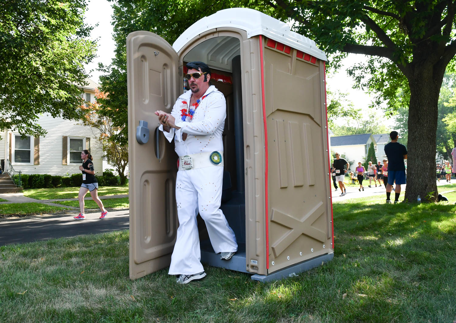 Running Elvis Scott Cullen, of Taylor Ridge, survives the port-a-potty along Kirkwood Blvd. during the Quad-City Times Bix 7 Saturday, July 28, 2018 in Davenport, Iowa. Upon exiting the port-a-potty Cullen quipped "Wow. I smells like something died in there." (Todd Mizener - Dispatch/Argus) 