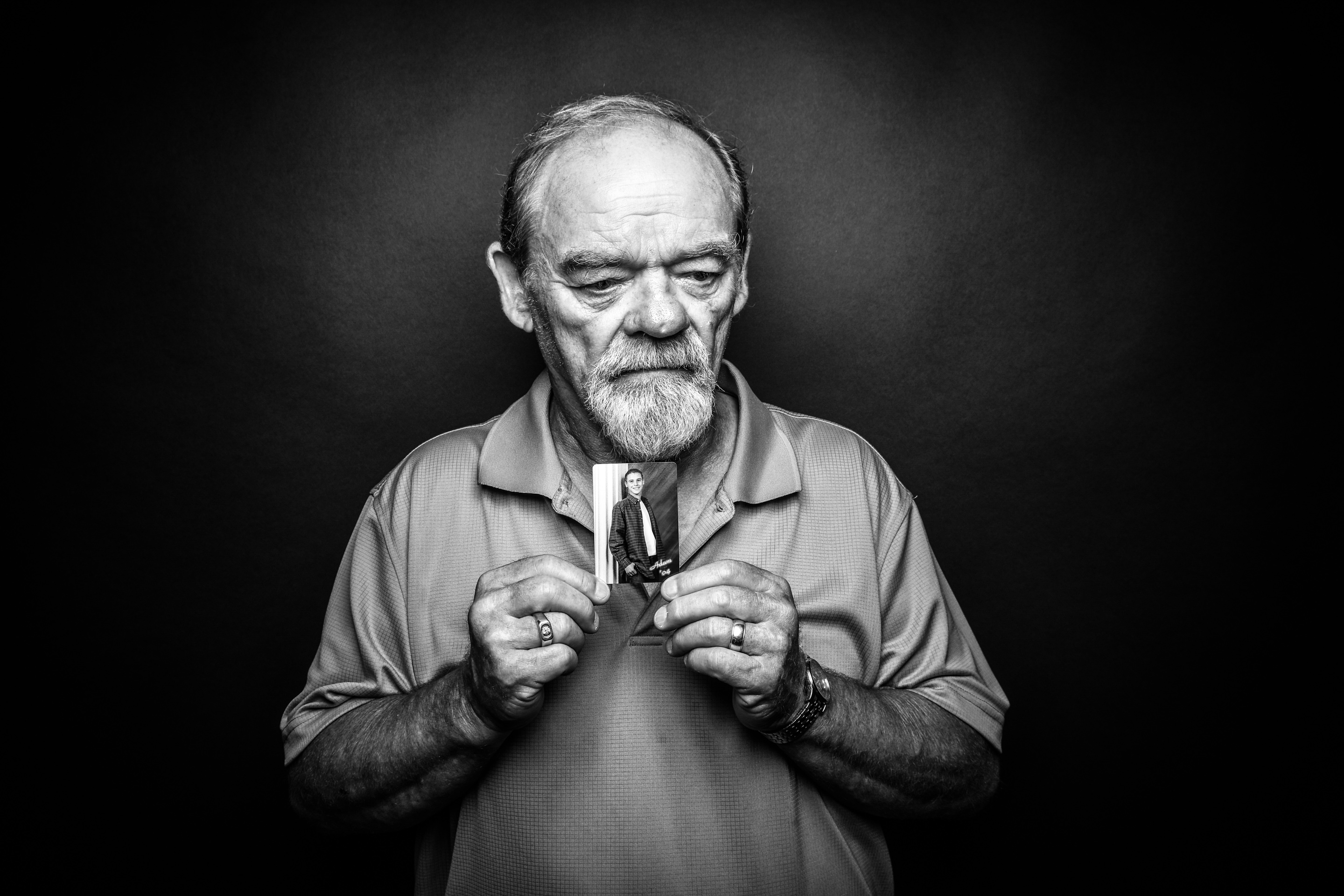 George Smith, East Moline, holds a photo of his son Adam, who died by suicide at 26, in 2012.