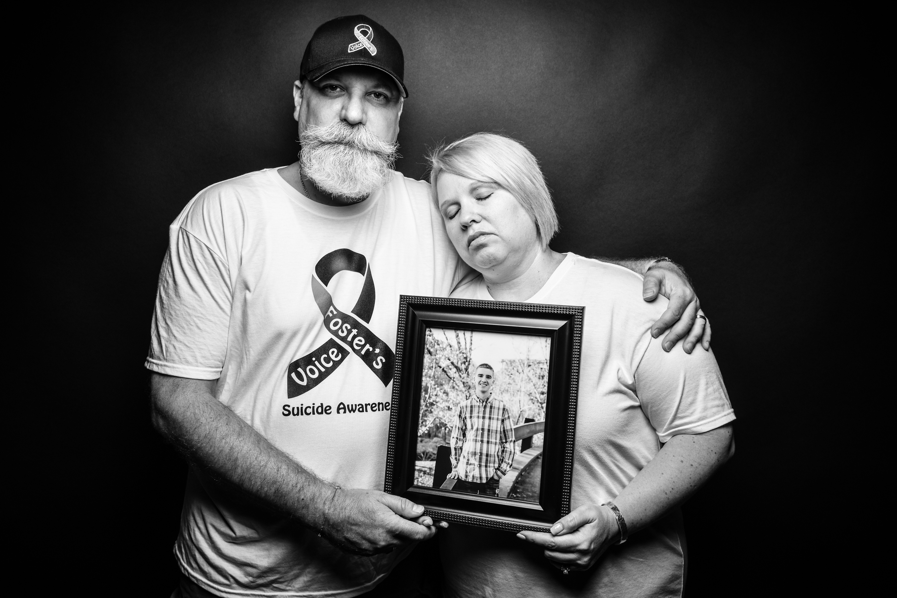Kevin and Jaime Atwood, East Moline, holds a photo of their son Foster, who died by suicide at 19, in 2017.