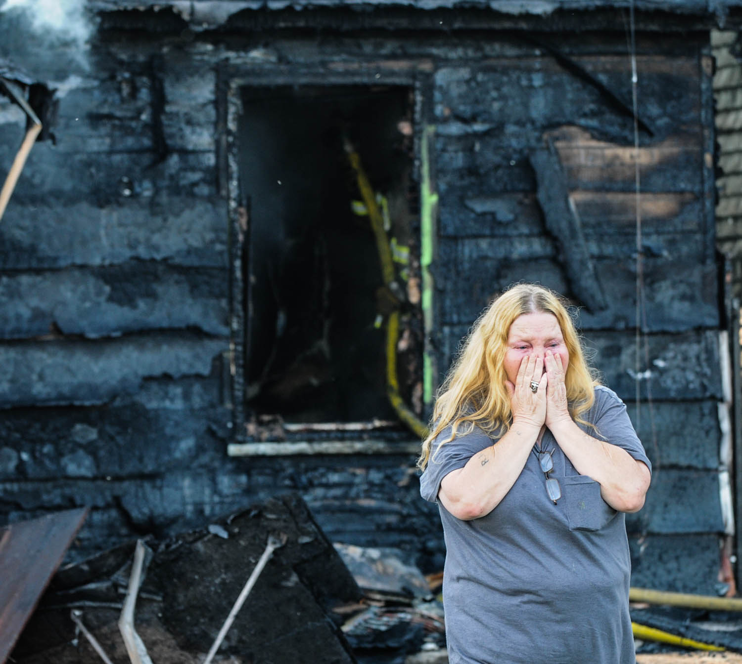 Barb Lucia, of East Moline, reacts to the early-morning fire which destroyed the house she was living in at 1339 17th St., East Moline. Ms. Lucia was not at home when the fire broke out about 6:30 this morning. The three people asleep inside the home escaped uninjured. (Todd Mizener - Dispatch/Argus)