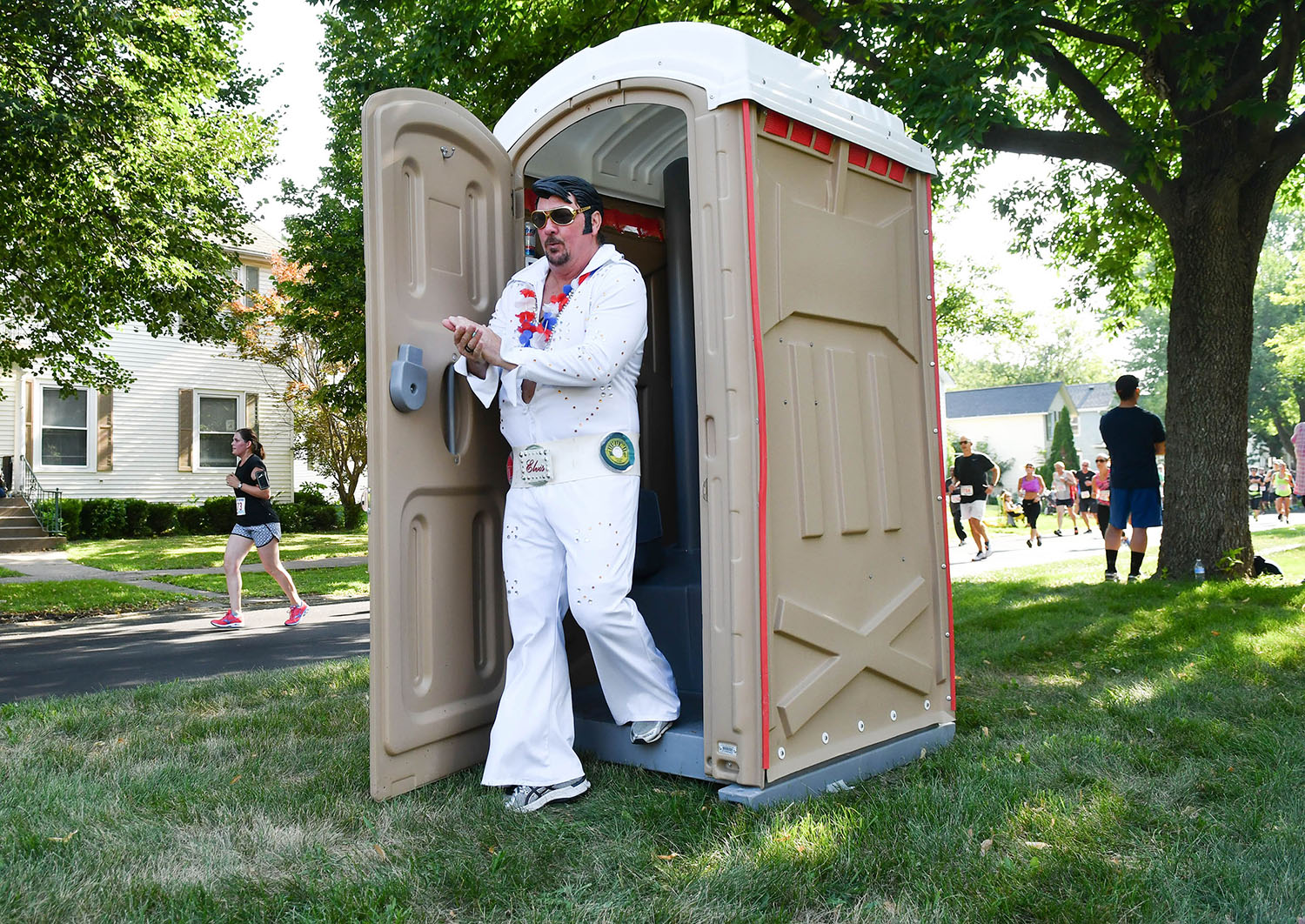 Running Elvis Scott Cullen, of Taylor Ridge, survives the port-a-potty along Kirkwood Blvd. during the Quad-City Times Bix 7 Saturday, July 28, 2018 in Davenport, Iowa. Upon exiting the port-a-potty Cullen quipped "Wow. I smells like something died in there."  (Todd Mizener - Dispatch/Argus)