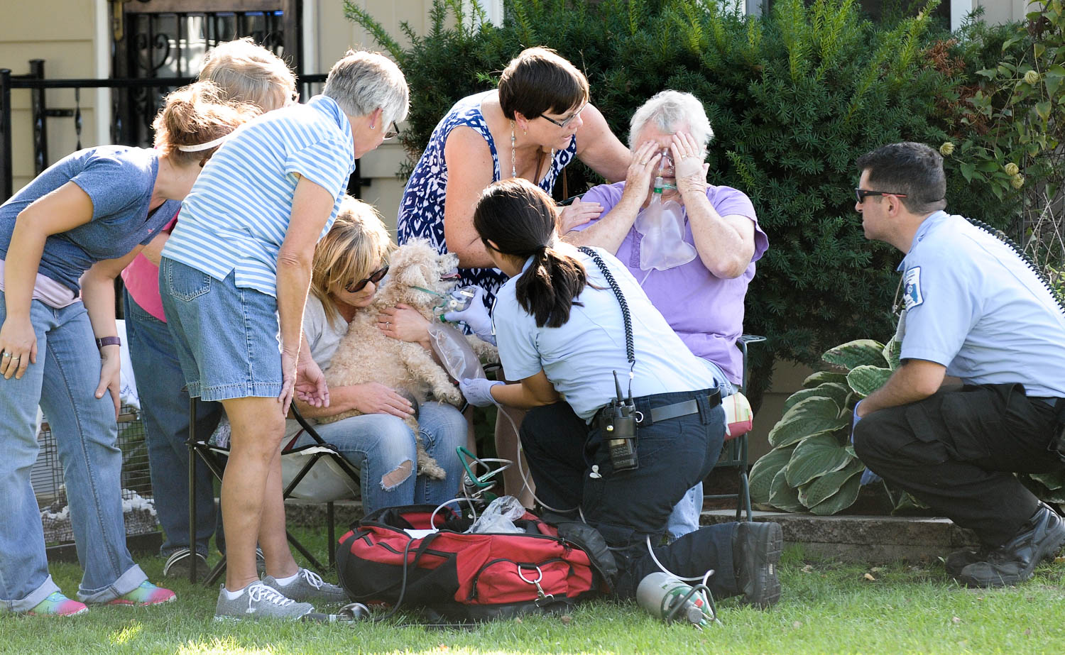 Emergency personnel give oxygen to Pat Myers and her dog, while friends comfort her following a fatal fire at her home, 2413 44th Street Monday, Sept. 12, 2016, in Moline. Mrs. Myers husband, Howard "Dave" D. Myers, 80, died as a result of injuries suffered in the blaze, which broke out in the couple's basement. (Todd Mizener - Dispatch/Argus)