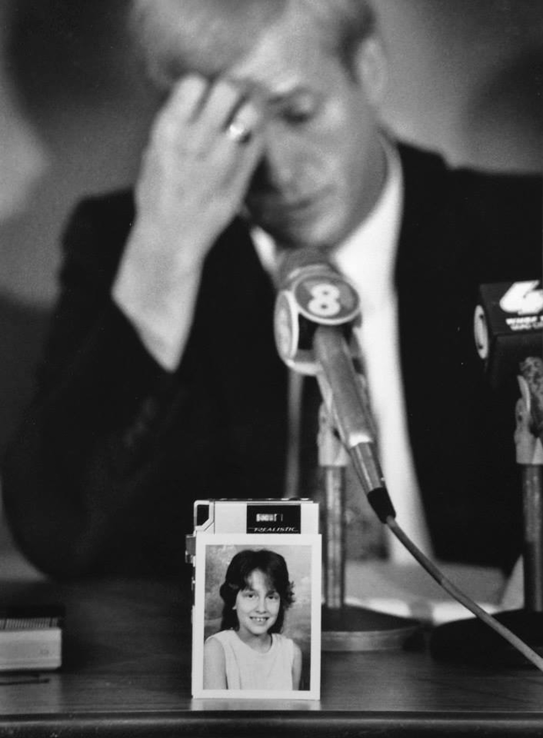 The school photo of murder victim Jennifer Ann Lewis rests against a reporter’s tape recorder as Davenport investigator Don Schaeffer pauses to collect himself while discussing the details of the case. The smoldering body of the 9-year-old, from Rock Island, Illinois,  was found the night before near Jefferson Elementary School in Davenport, Iowa.