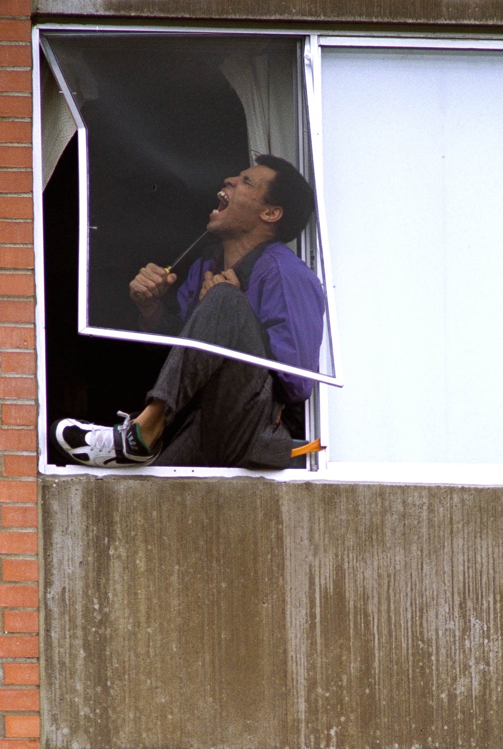 An unidentified man threatens to commit suicide in the window of his Moline apartment. Police were able to talk him out of the third story window without incident after an hour long stand-off. Police officials refuse to release the subject's name. (Todd Mizener - Dispatch/Argus)