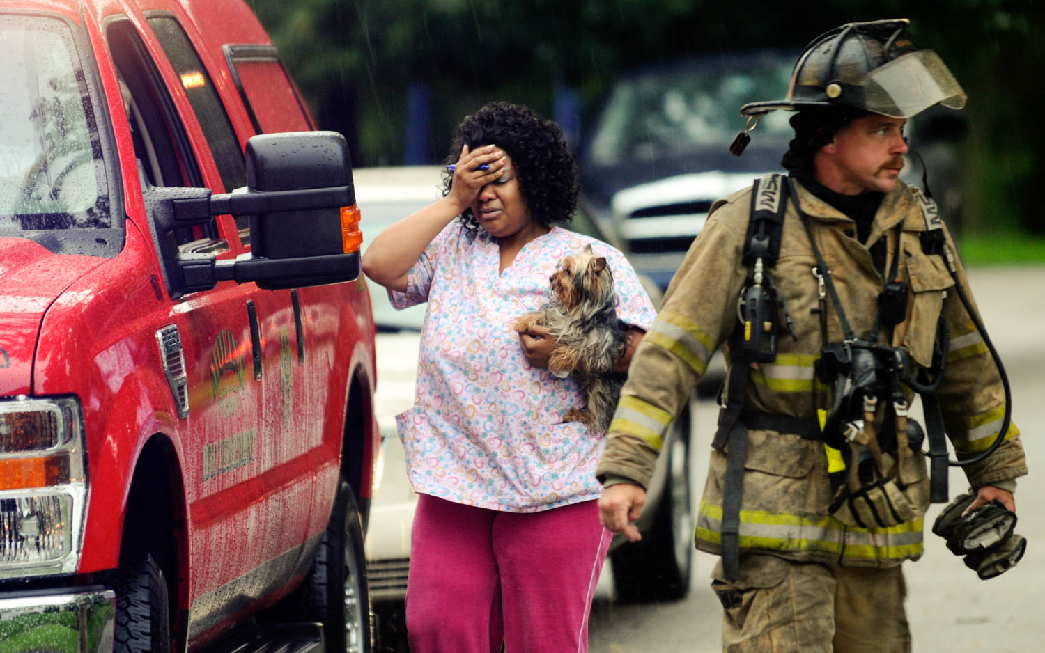 Katrina Jackson, of Moline, holds her dog close after the animal was rescued from a fire which damaged the duplex she lives at 1433 28th Ave. in Moline June 23, 2010. The fire was confined to a second floor bedroom on the south side of the duplex. (Todd Mizener - Dispatch/Argus)