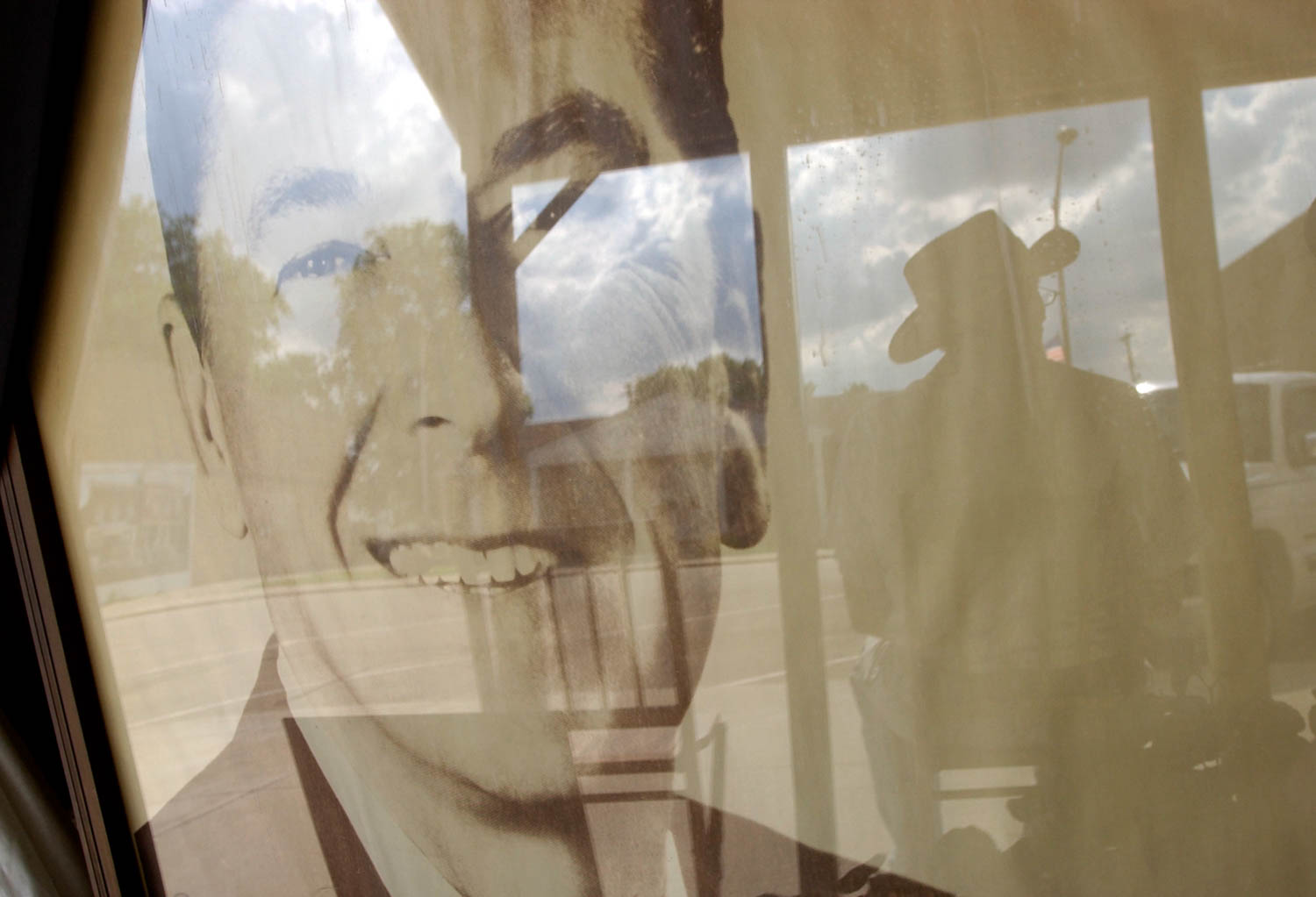 The reflection of Tim McLoughlin of Tampico Ill., casts a silhouette next to a large portrait of former President Ronald Reagan in the window of the Tampico historical society, Sunday afternoon. Reagan was born in Tampico, on Feb. 6, 1911 and died Saturday at the age of 93. (Todd Mizener - Dispatch/Argus)