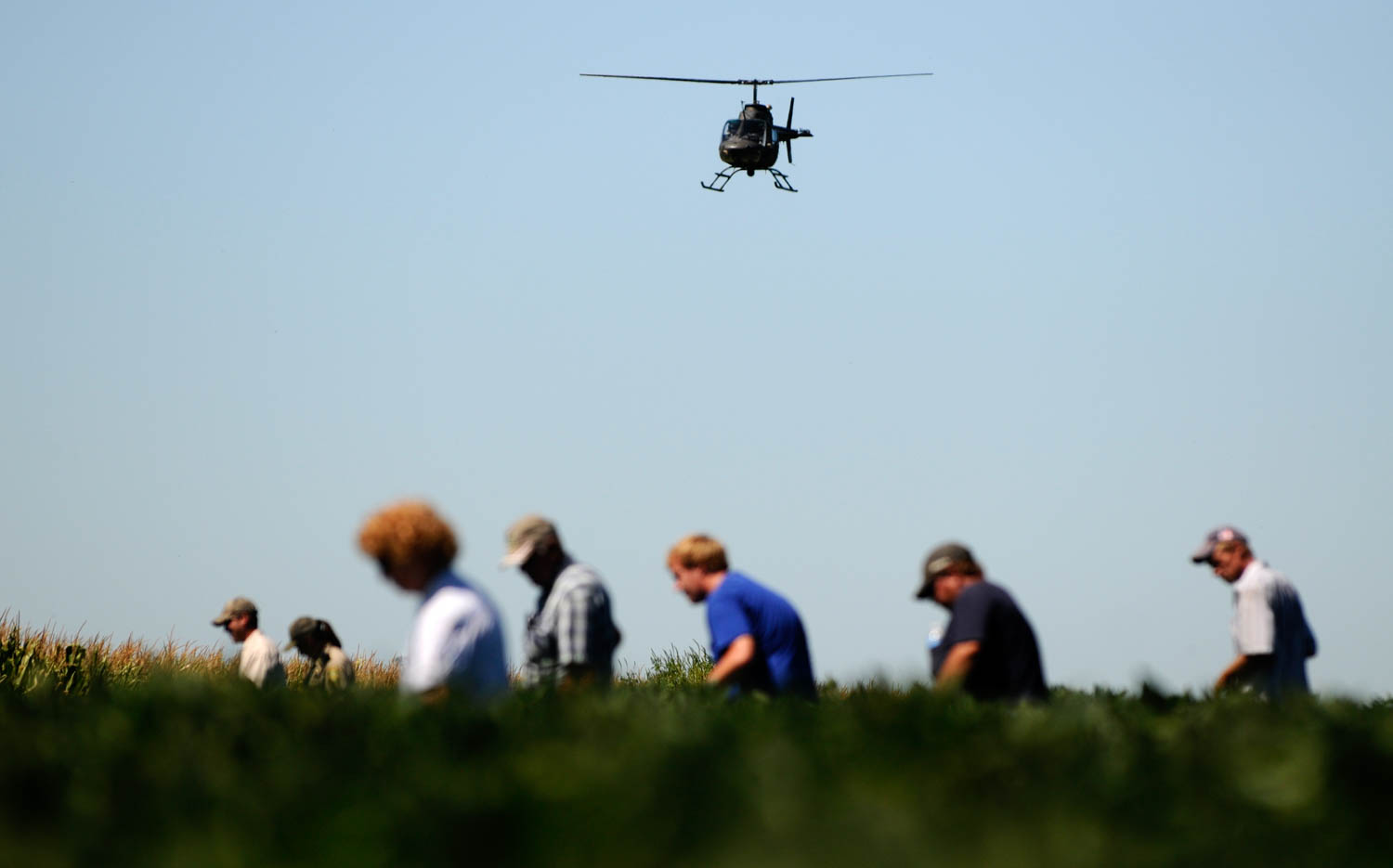 While helicopter searches from above volunteers and law enforcement search the soybean field north of the house where a 2-year-old boy went missing from on Monday August 6, 2012. The little boy was reported missing shortly after 10:30 a.m. this morning, he was found after being lost for hours in a farm field. According to Jeff Dale, chief deputy of the Mercer County Sheriff's Office, the boy was found uninjured three-quarters of a mile northwest of the home. (Todd Mizener - Dispatch/Argus)