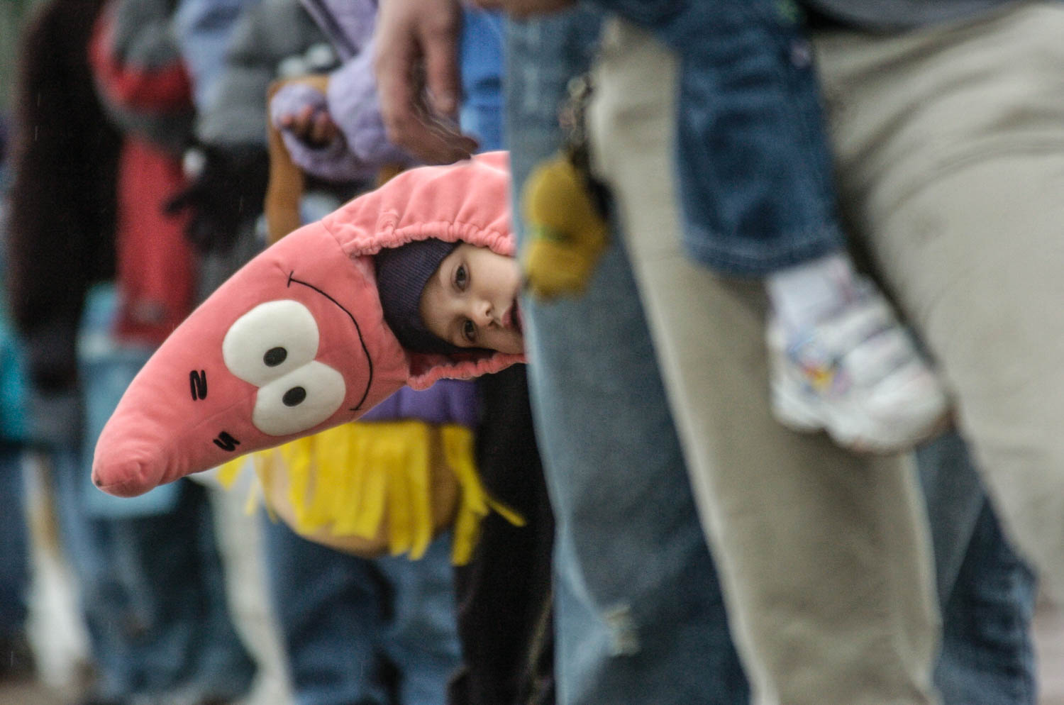 Sebastien Cortez, 5 of Moline, sports a Patrick the Starfish costume, a character from the cartoon SpongeBob SquarePants, as he peeks around the crowd gathered along Avenue of the Cities Sunday afternoon for the Moline Council of Associated Dad's Clubs 48th annual Halloween parade. (Todd Mizener - Dispatch/Argus) 