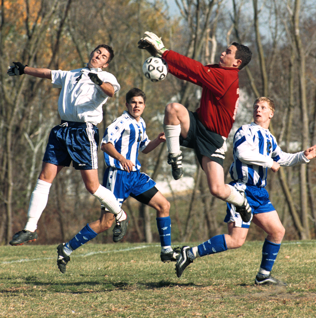 Marycrest International University goalie Kevin Rugaard makes a leaping save versus a header attempt by St. Ambrose University midfielder Damon Wagner. Looking on are two MIU defenders. (Todd Mizener - Dispatch/Argus)