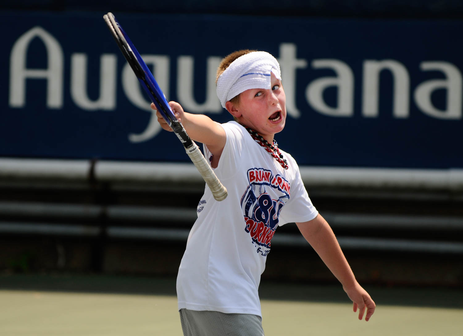 Eli Boeye, 9, of Milan, is pumped up after making a good shot during his tennis lesson at Augustana College on Monday, July 23, 2012. Eli and three other tennis students braved Monday's 102-degree temperatures to participate in a tennis lesson with Quad City Tennis Club pro Dan Patrick. (Todd Mizener - Dispatch/Argus)